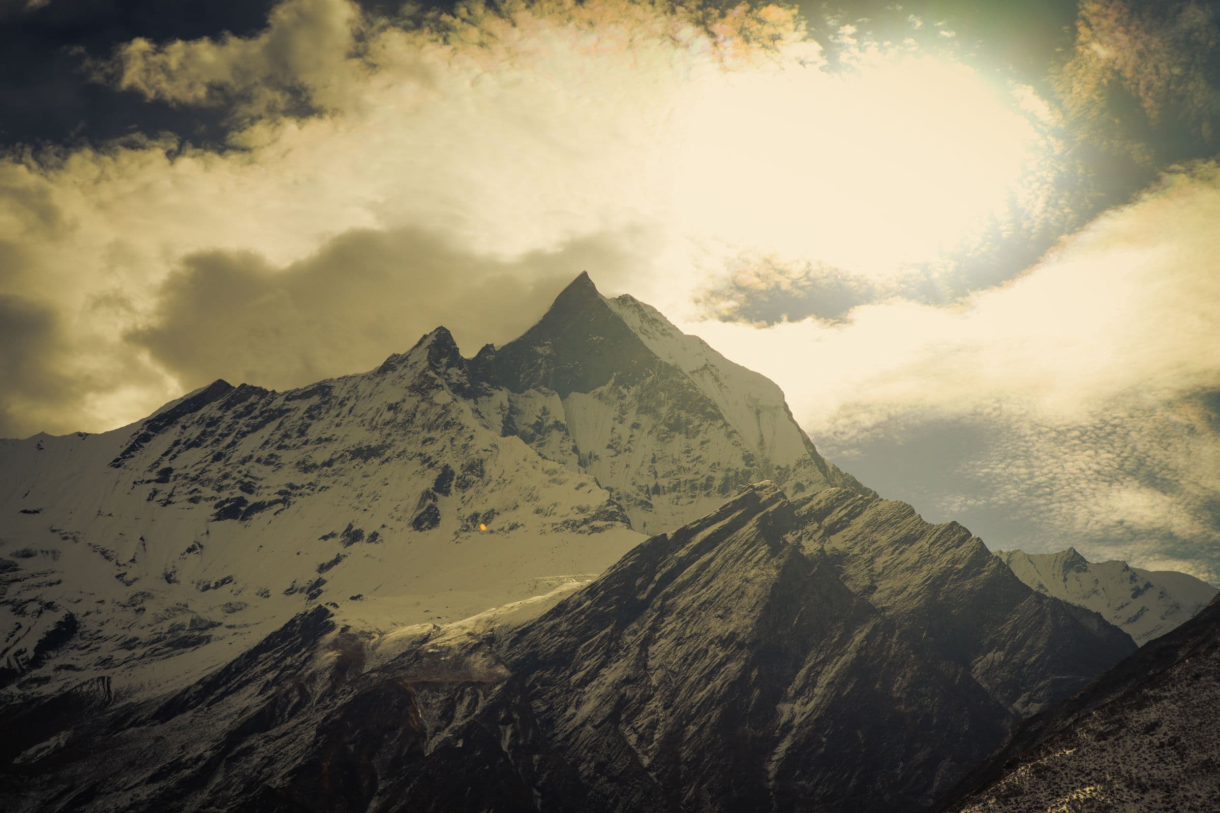 Breathtaking view of Mount Annapurna with dramatic clouds and snow-capped peaks in Nepal.