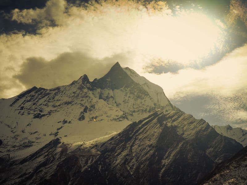 Breathtaking view of Mount Annapurna with dramatic clouds and snow-capped peaks in Nepal.