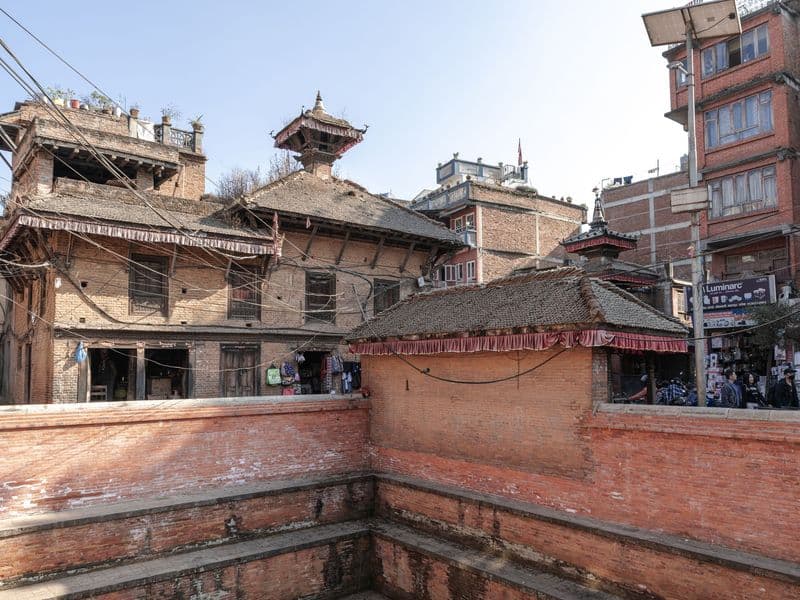 Historic brick buildings in Bhaktapur, Nepal's ancient cityscape under clear skies.