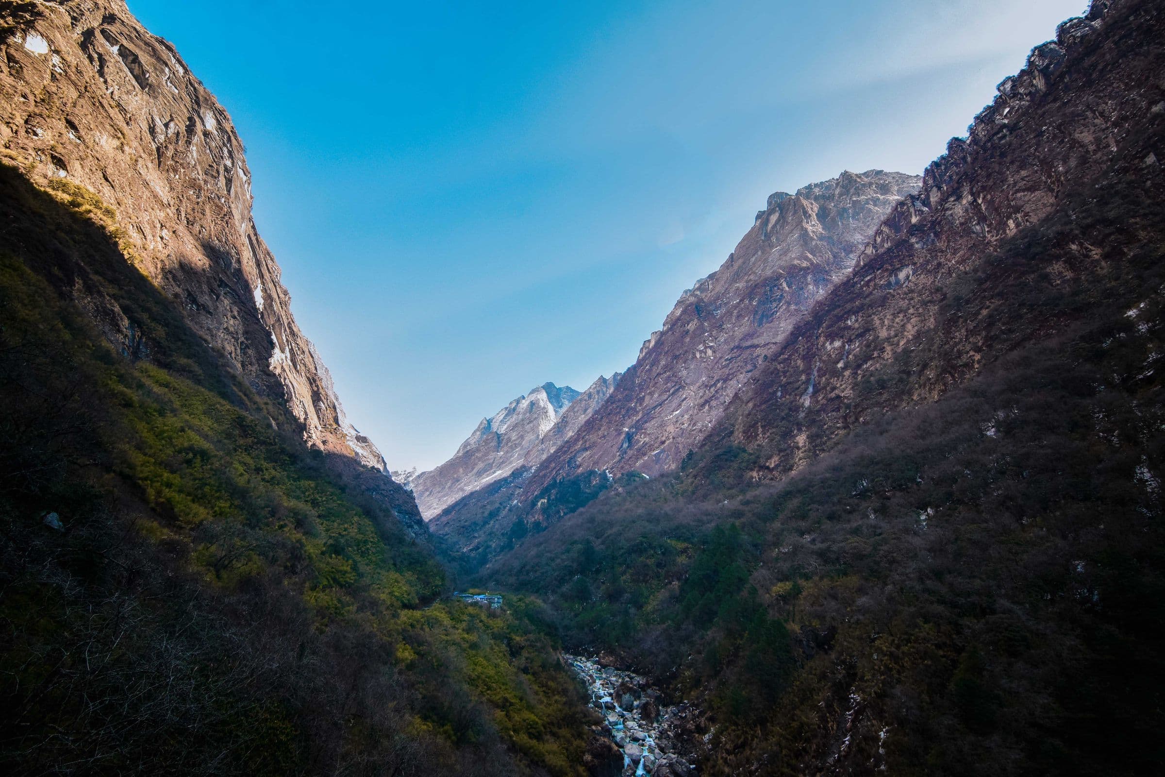 Stunning view of Deurali valley in the Himalayas, showcasing rugged landscapes and blue skies.
