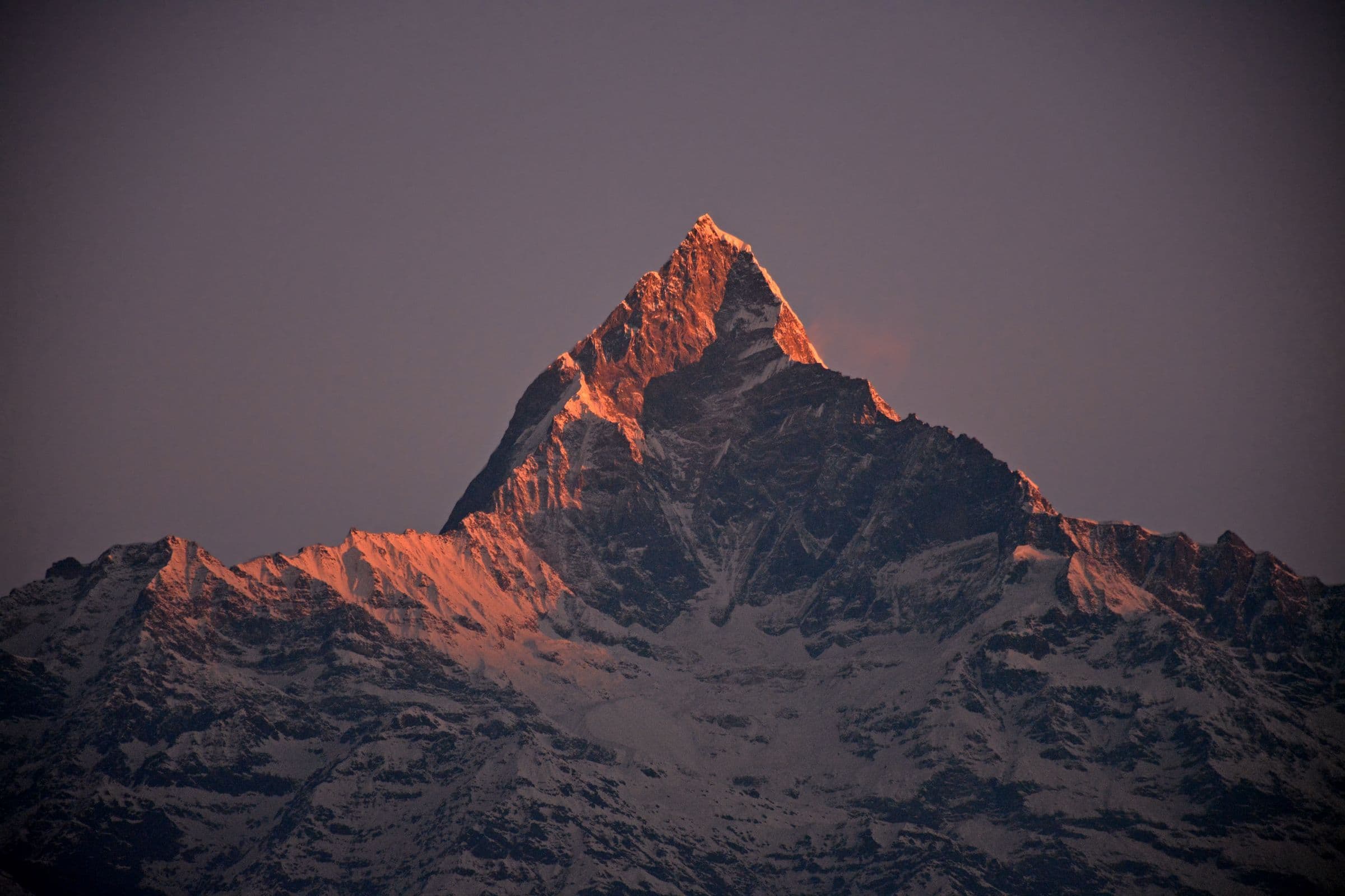 A stunning sunset captures the snow-covered Machapuchare Peak in the Annapurna range, Nepal.