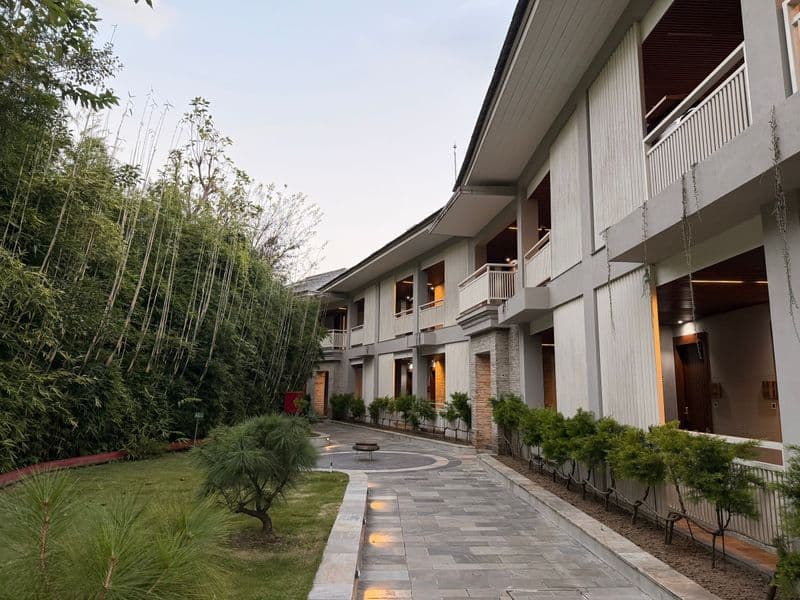 A tranquil modern hotel exterior with bamboo and lush greenery in the peaceful outdoor setting of Nagarkot, Nepal.